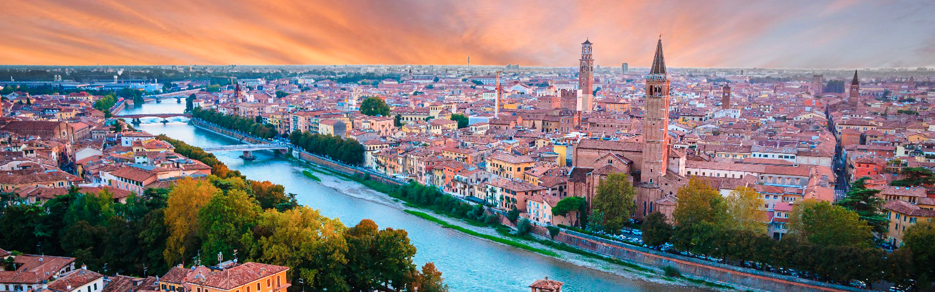Veduta della città di Verona al tramonto che abbraccia le due sponde del fiume Adige.